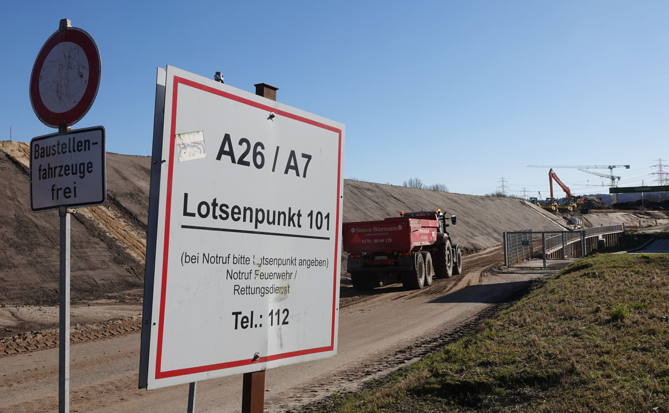 Ein Fahrzeug fährt zur Baustelle der Autobahn A26 neben der Autobahn A7.