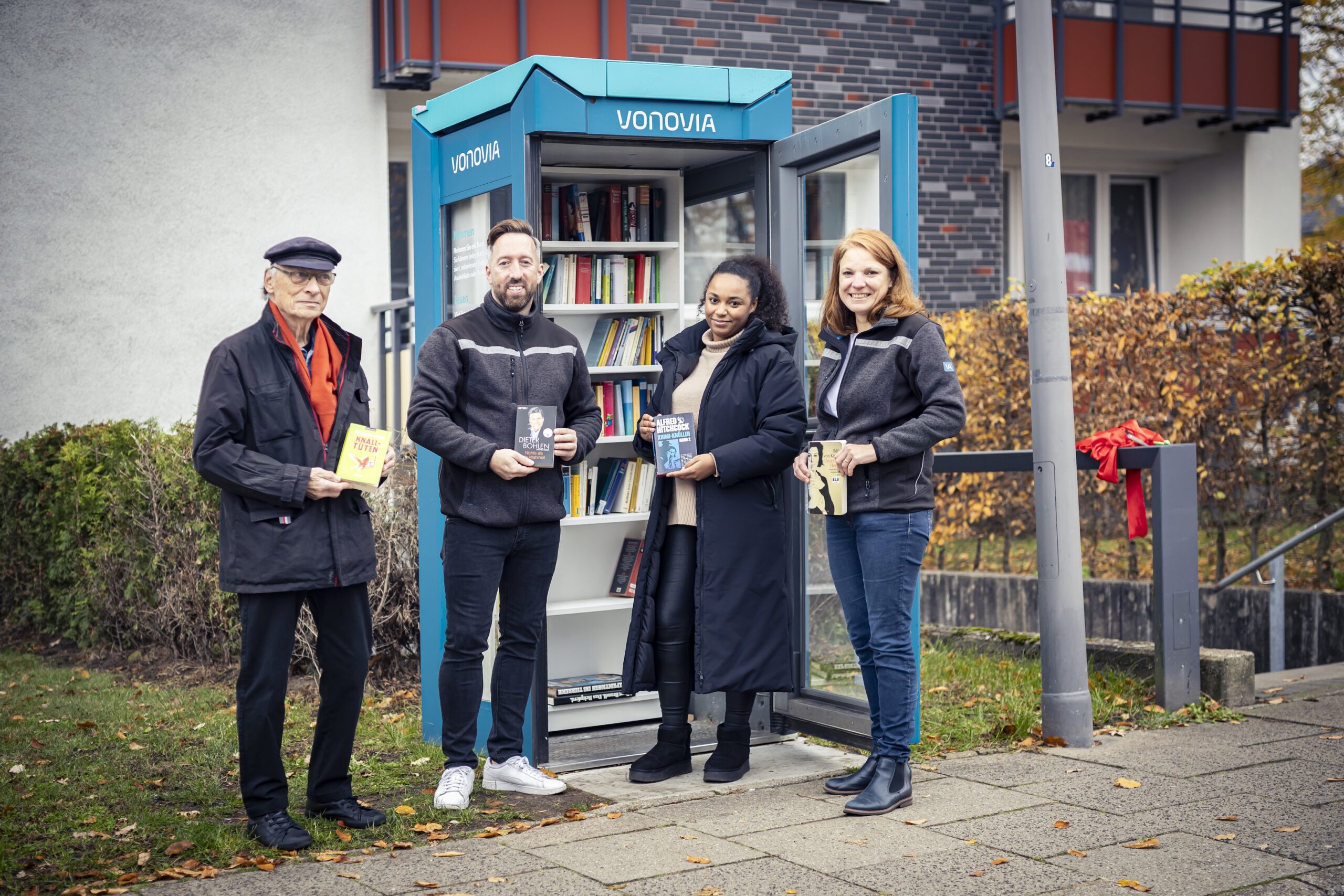 Vonovia Mieter Rolf Schönlein (links) mit drei Vonovia Mitarbeitern vor der neuen „Lesbar“ in Rissen