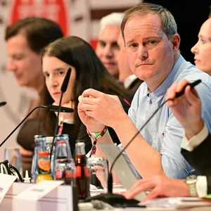 St. Pauli-Präsident Oke Göttlich schaut auf einer Versammlung ernst