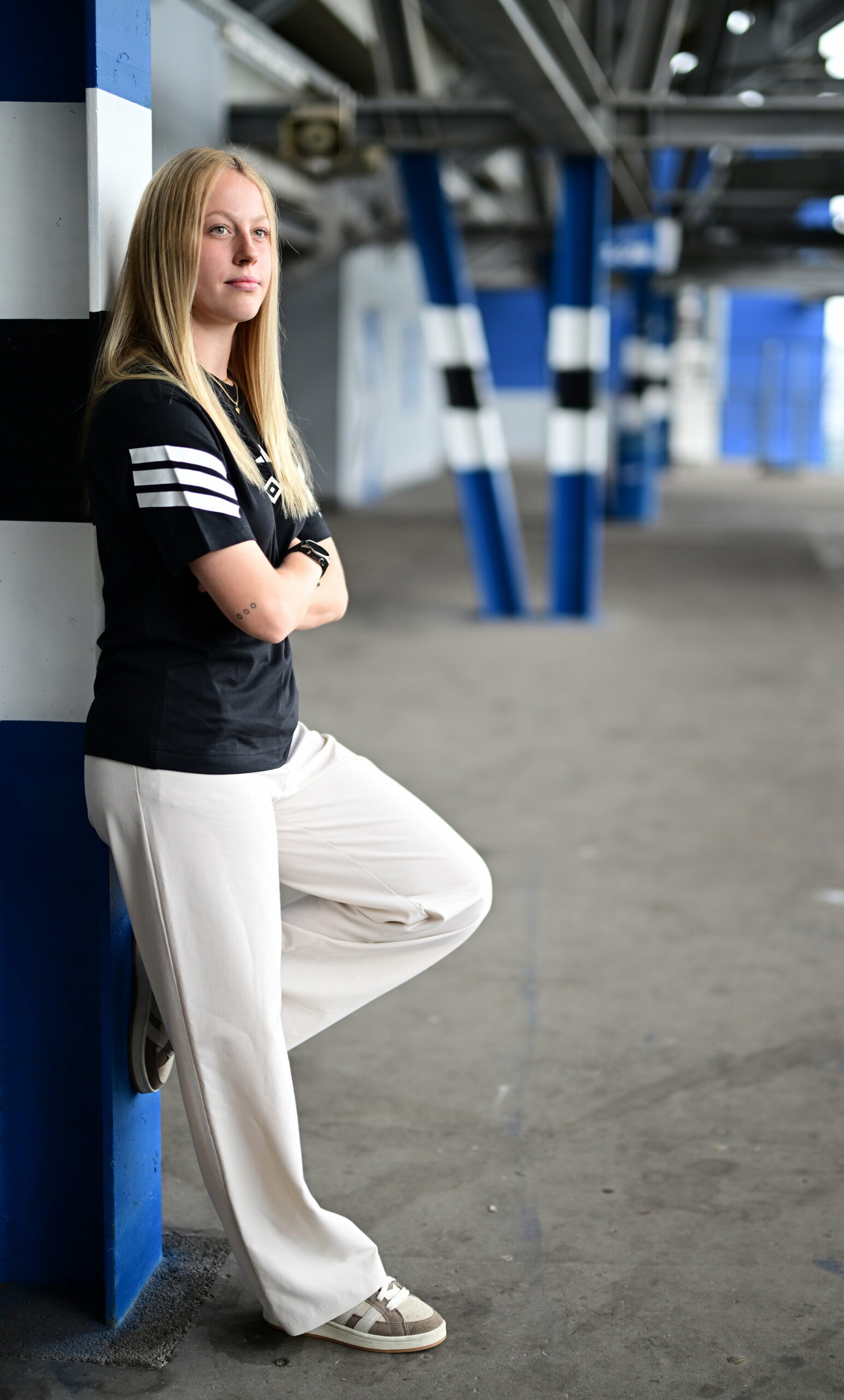 Larissa Haidner lehnt sich an einen blau-weiß-schwarzen Pfosten im Volksparkstadion des HSV