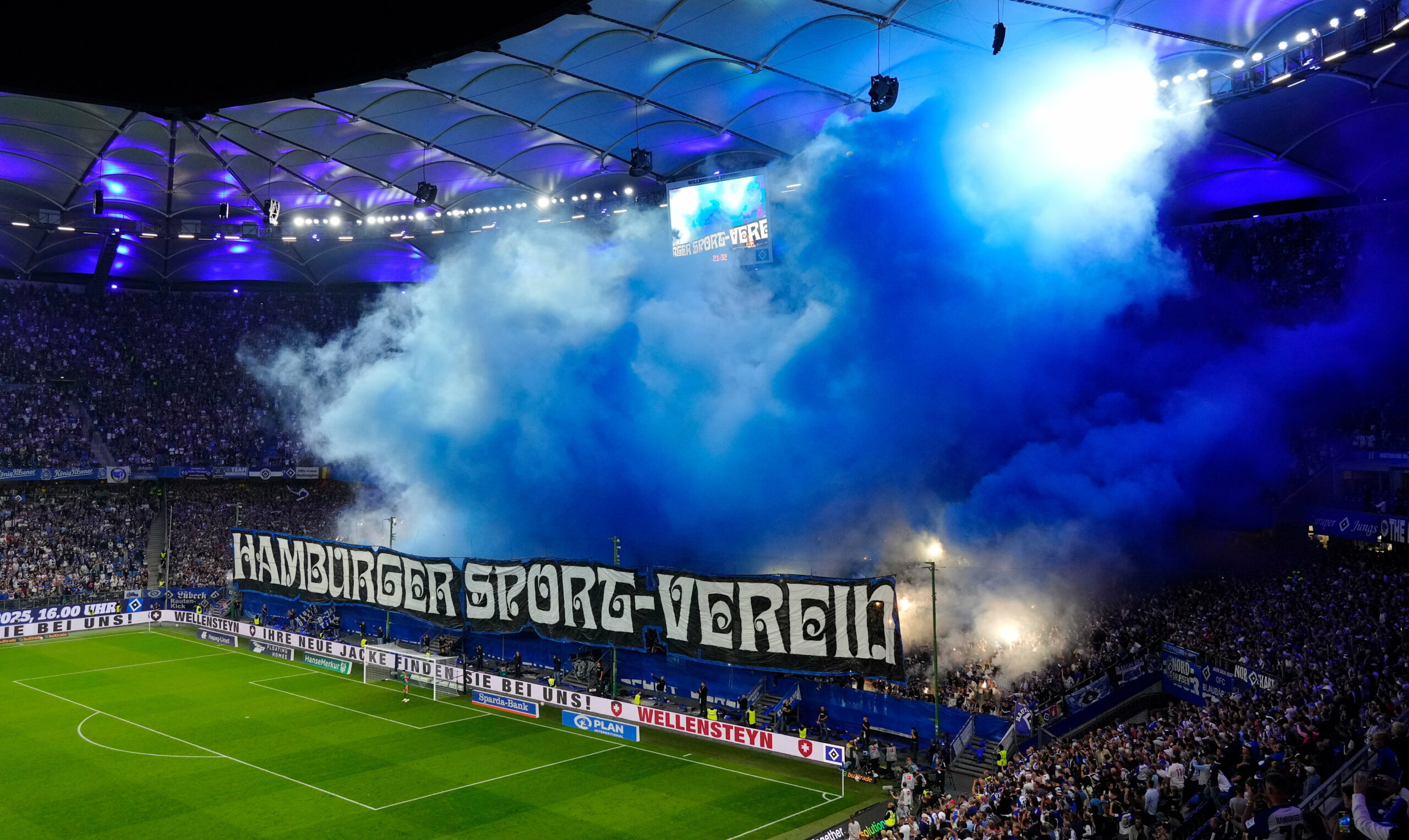 HSV-Fans zünden auf der Nordtribüne im Volksparkstadion blaue Rauchtöpfe.
