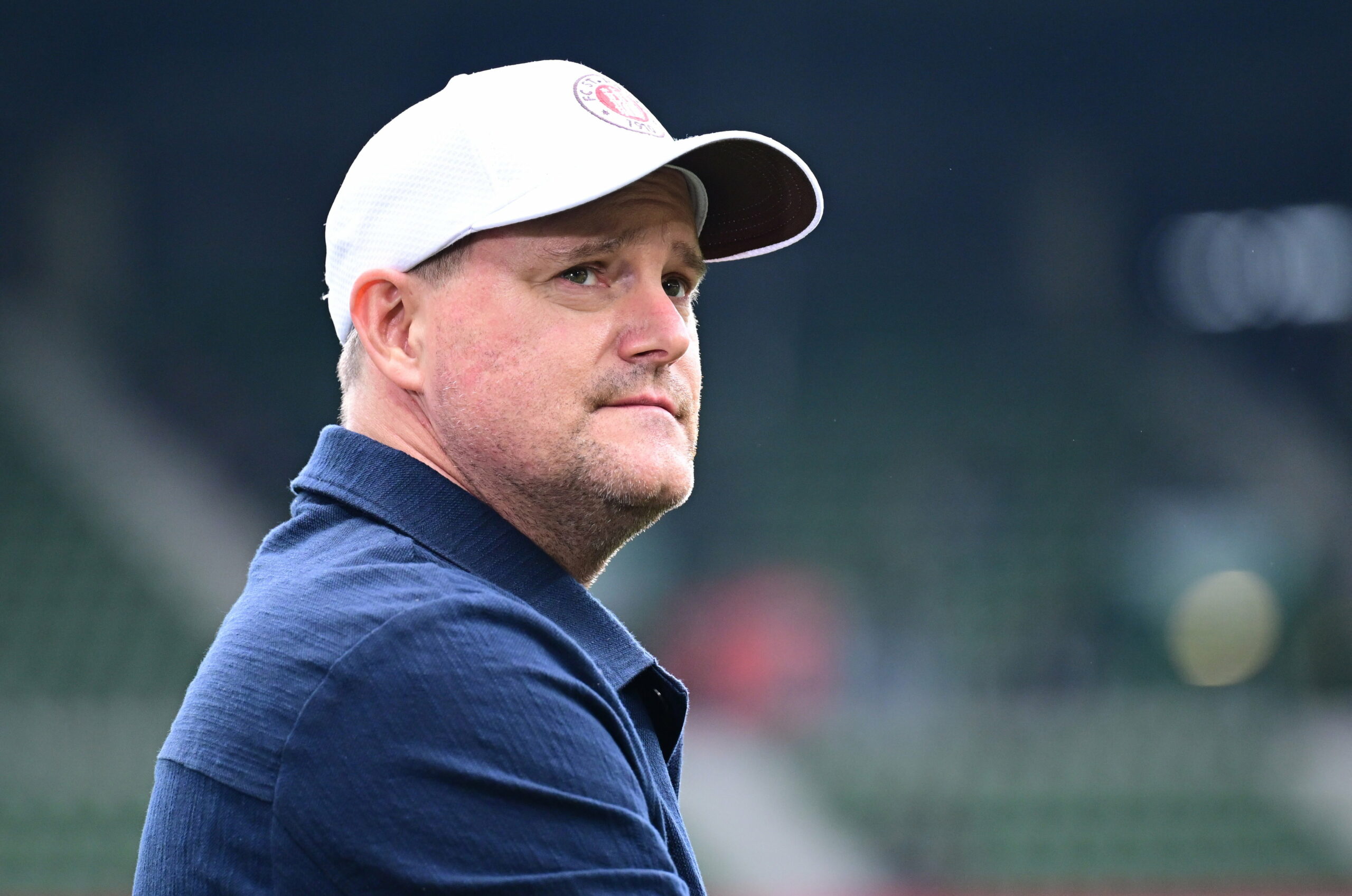 Oke Göttlich mit Cap auf dem Kopf schaut nach rechts.