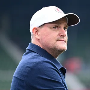 Oke Göttlich mit Cap auf dem Kopf schaut nach rechts.