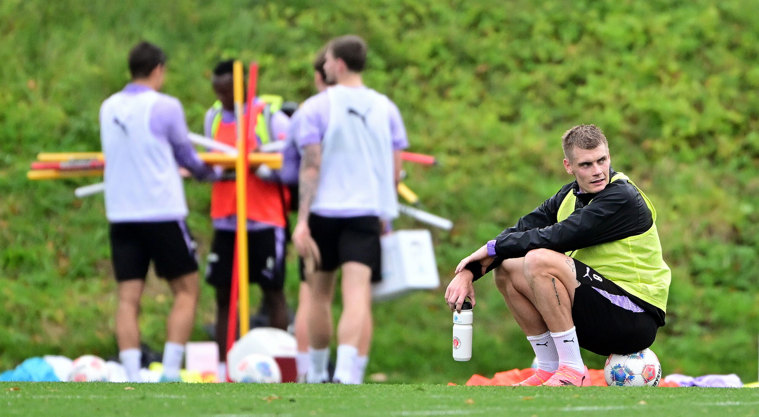 Eric Smith sitzt im St. Pauli-Training auf einem Ball