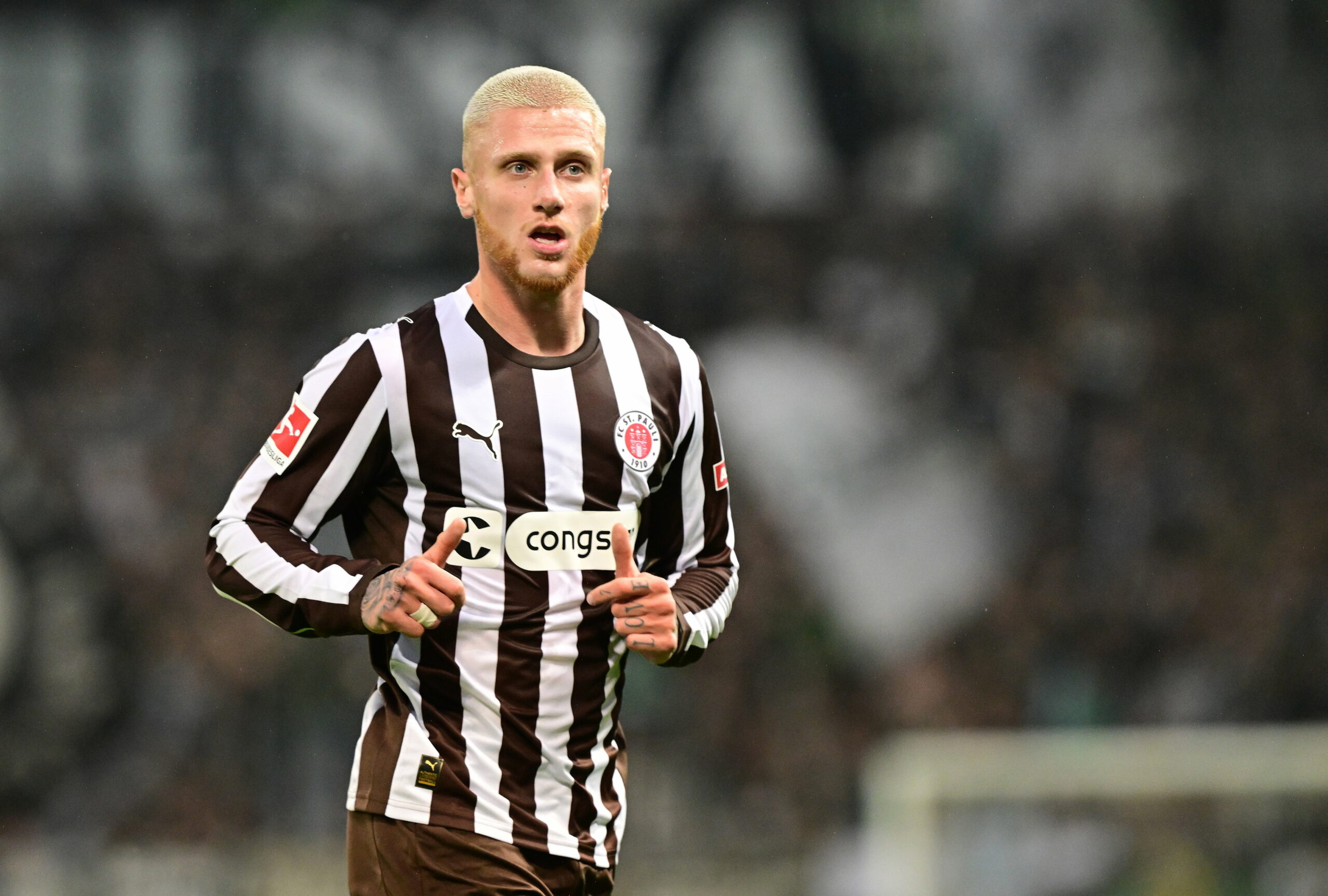 Louis Oppie im St. Pauli-Trikot joggend.