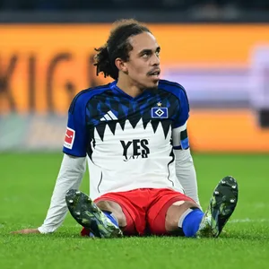 Yussuf Poulsen sitzt auf dem Rasen des Volksparkstadions.