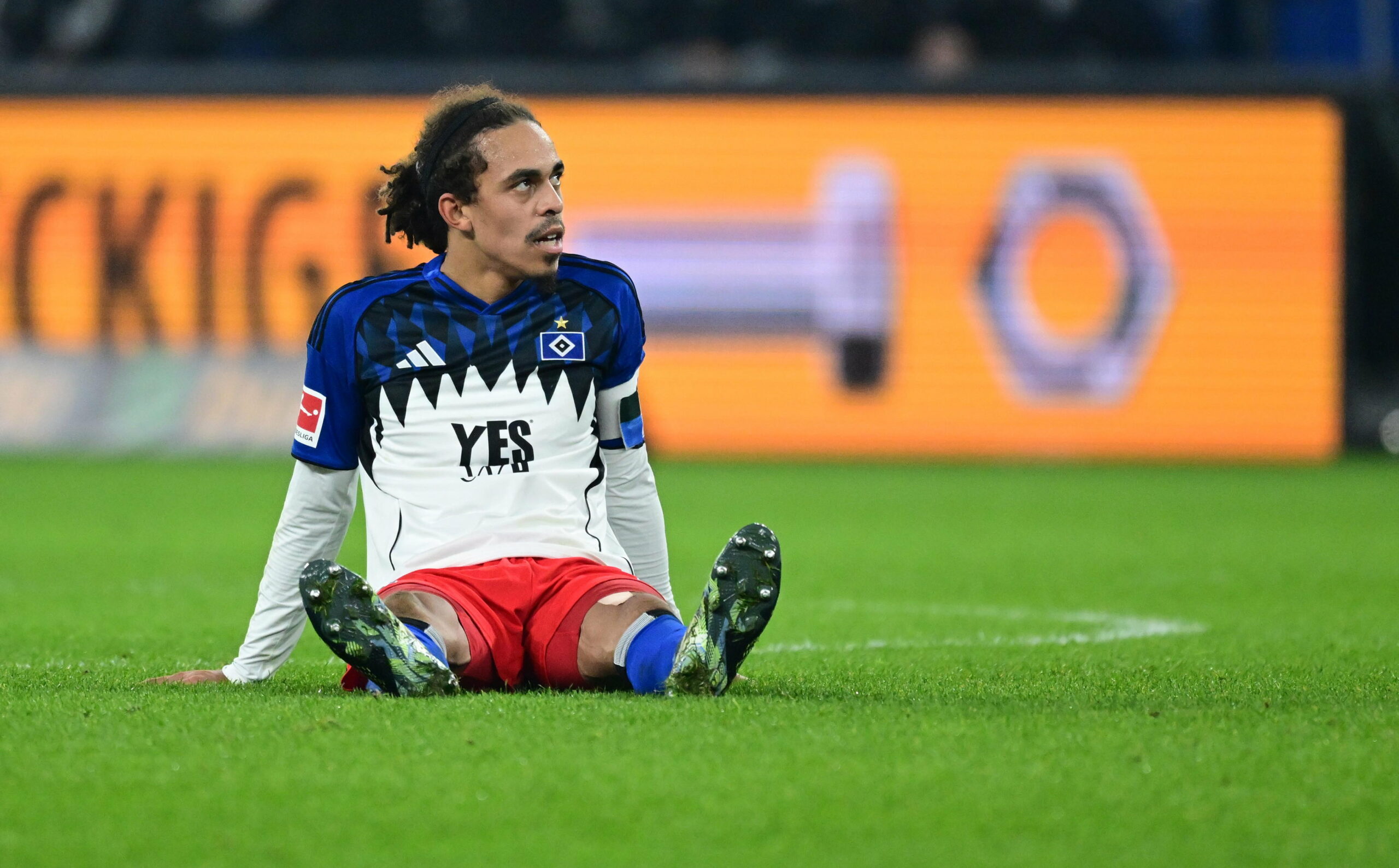 Yussuf Poulsen sitzt auf dem Spielfeld im Volksparkstadions