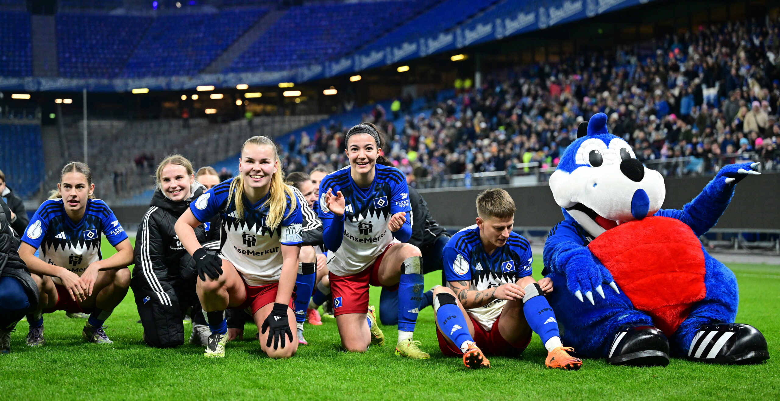 Maskottchen Dino Hermann feiert den Sieg mit den HSV-Frauen