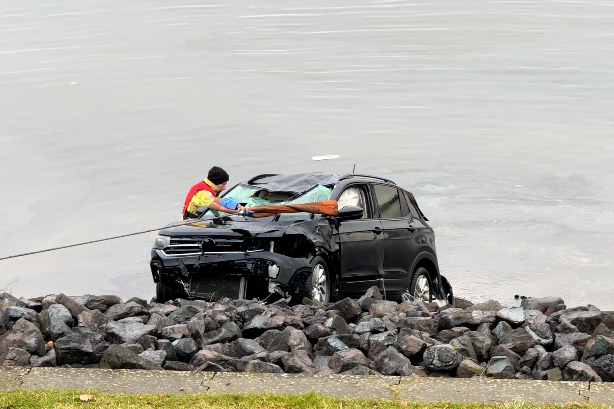 Rettungskräfte befreiten eine Person aus dem sinkenden Wagen.