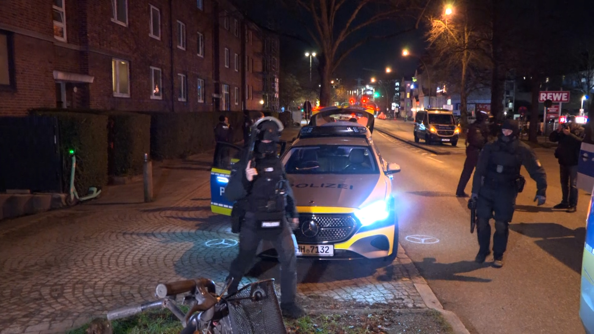 Bewaffnete Polizisten stehen vor dem Haus an der Borsteler Chaussee.