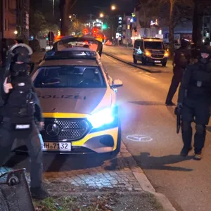 Bewaffnete Polizisten stehen vor dem Haus an der Borsteler Chaussee.