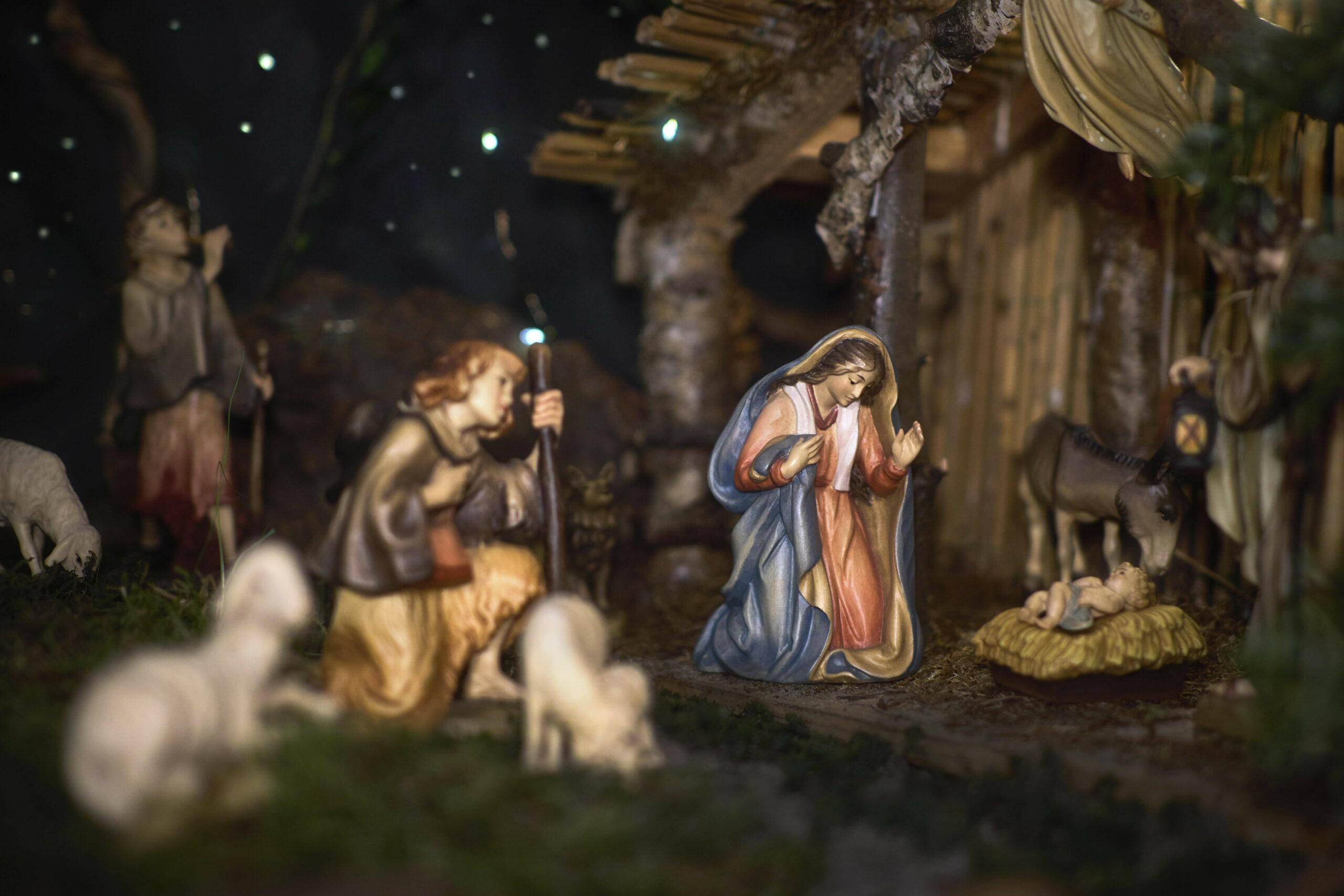 Eine Weihnachtskrippenszene mit wunderschön geschnitzten Figuren, darunter das Jesuskind, Maria, Joseph, Hirten und Tiere.