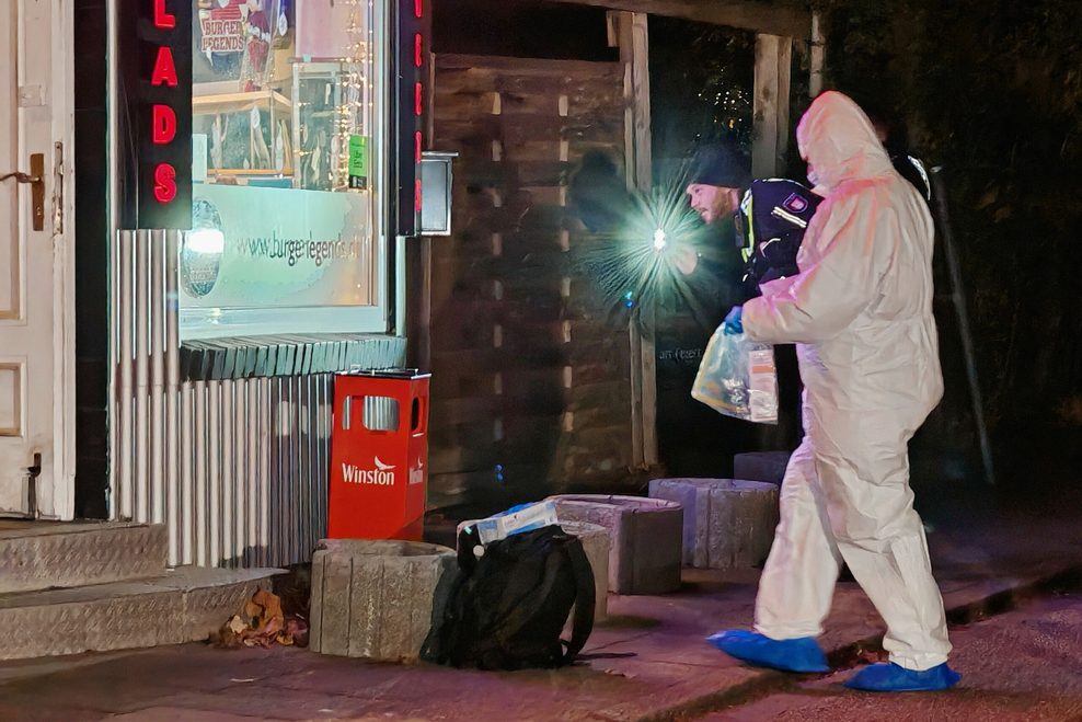 Einsatzkräfte der Polizei stehen vor dem Tatort