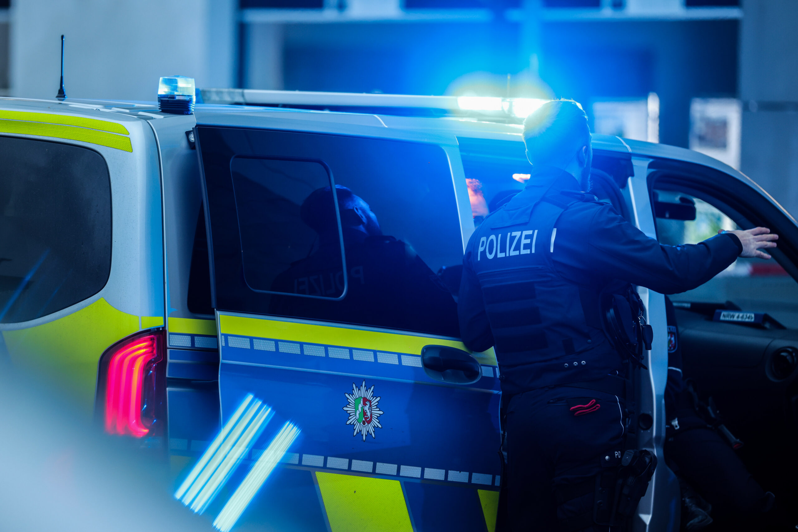 Ein Polizist bei einem Einsatzwagen (Symbolbild).