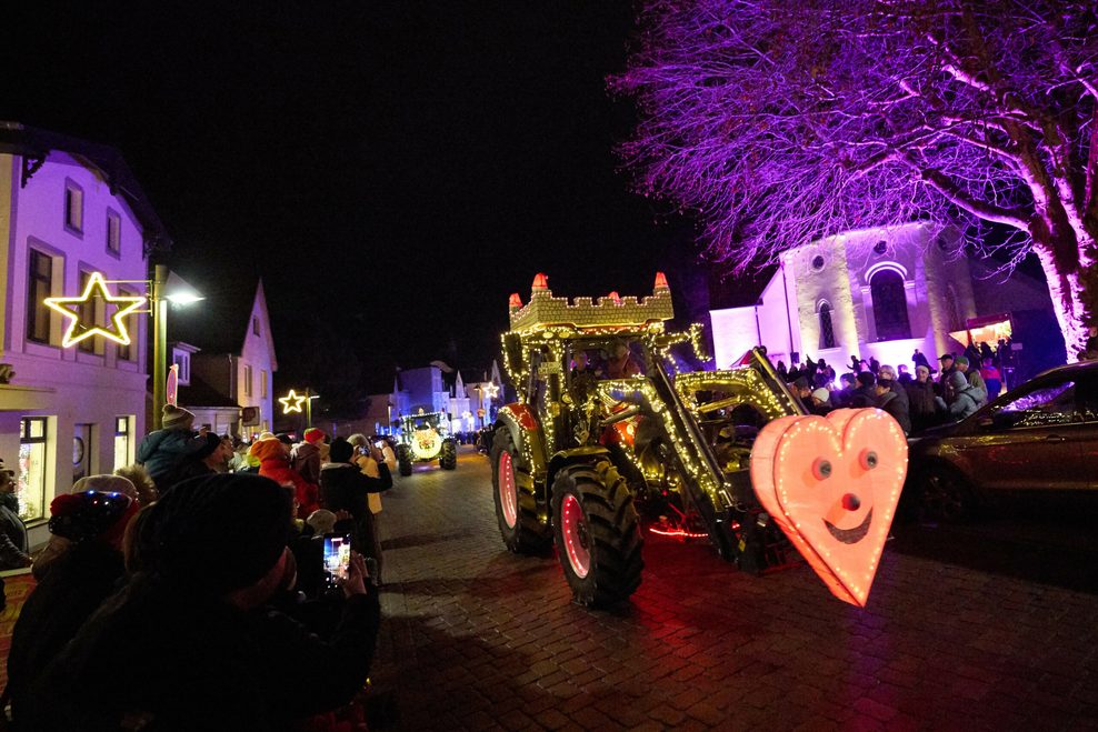 Eine Parade mit geschmückten und beleuchteten Treckern fährt durch den Ort. Landwirte aus Norddeutschland sammelten damit für kranke Kinder.