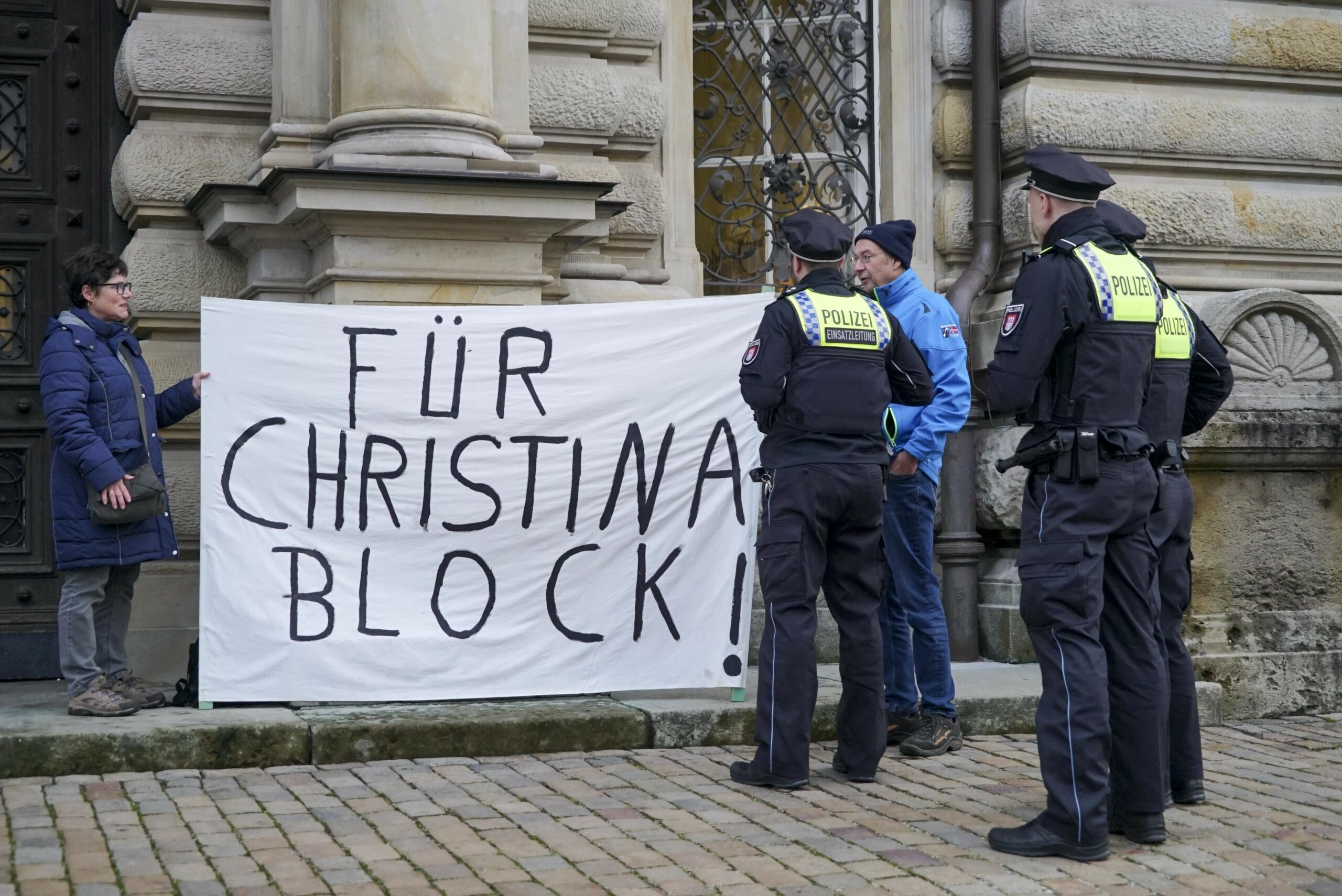 Das Ehepaar steht auch am Dienstag wieder vor dem Hamburger Strafjustizgebäude. Polizisten prüfen die Situation, haben aber nichts auszusetzen.