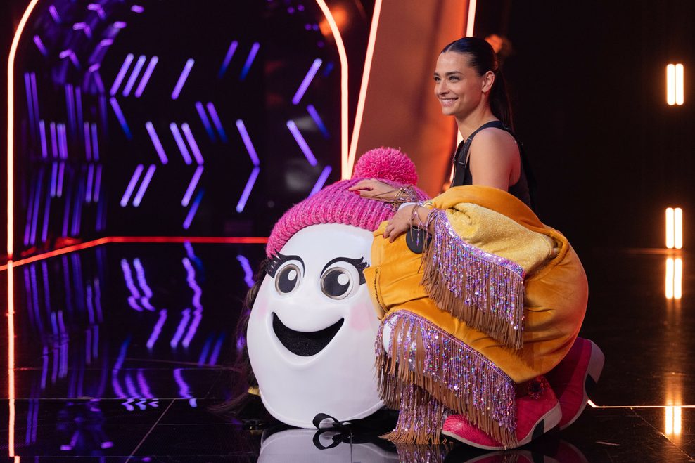 Moderatorin Amira Aly steht als enttarnte Figur „Eggi“ auf der Bühne. 