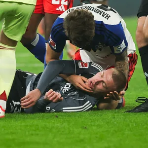 Rasmus Kristensen liegt am Boden und Luka Vuskovic stützt seinen Kopf