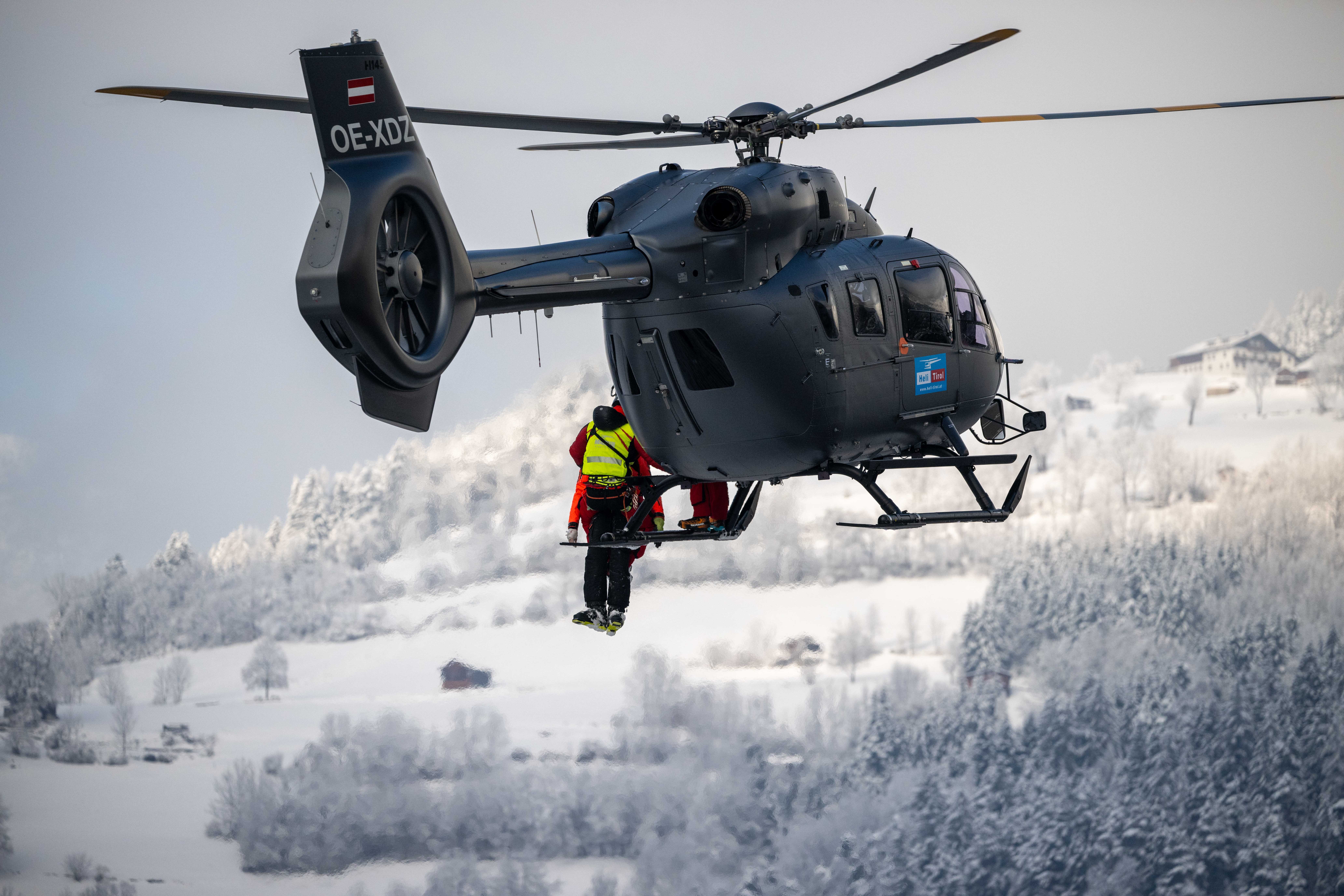 Bei der Bergung wird ein Retter zusammen mit einem Verletzten mit einer Seilwinde in einen Hubschrauber gezogen, der über der Absturzstelle einer Gondel der Acherkogelbahn steht.