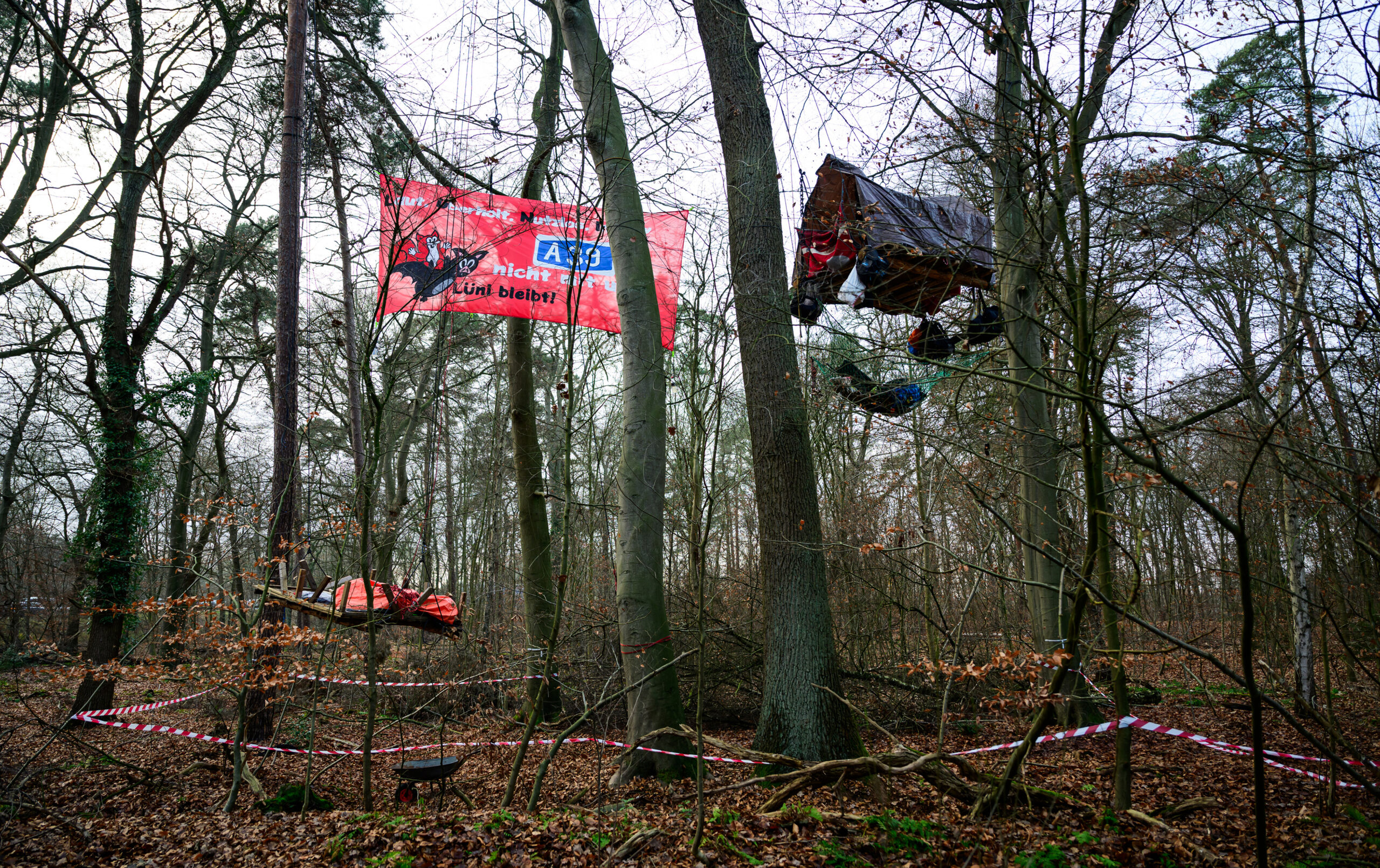 Eine Plattform von Aktivisten hängt im Wald neben einem Banner gegen den geplanten Ausbau der A39. Unter dem Motto "Lüni bleibt" protestiert die Gruppe gegen den Ausbau der A39.