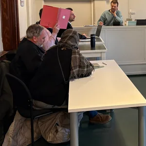 Amtsgericht Harburg: Die Angeklagte und ihr mitangeklagter Ehemann verbergen ihre Gesichter hinter Aktenmappen.