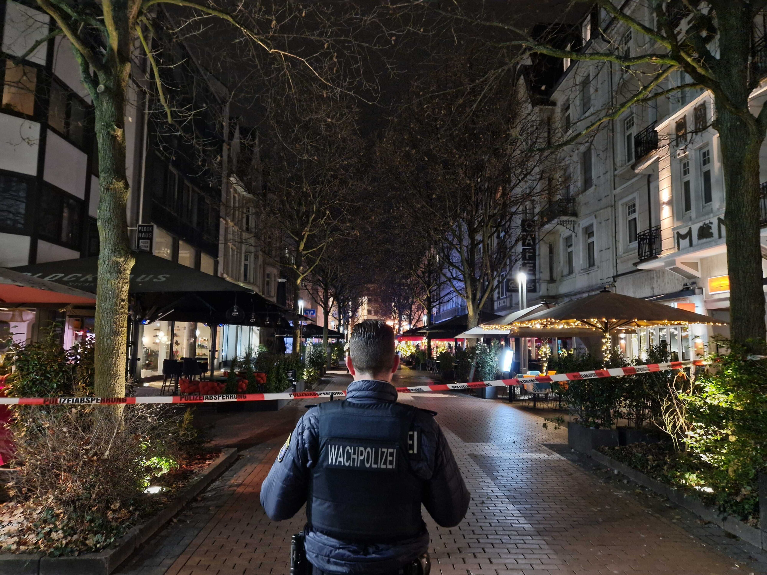Ein Mitarbeiter der Wachpolizei steht vor einem abgesperrten Bereich der Innenstadt von Gießen.
