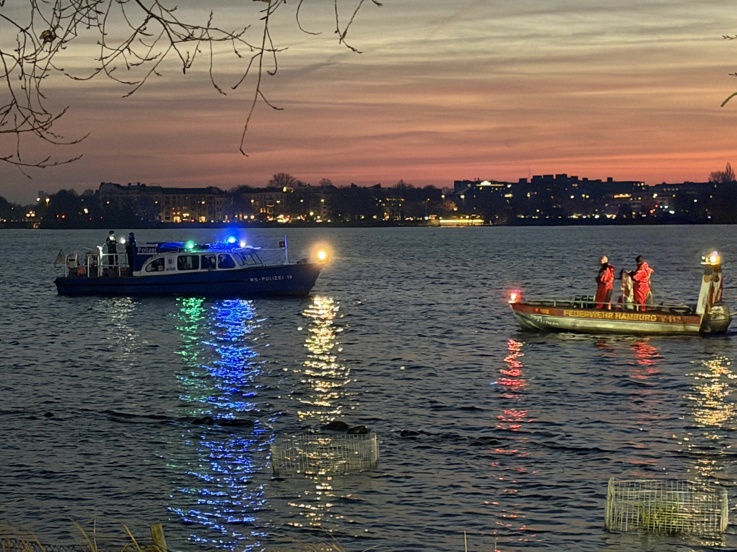 Auf der Hamburger Außenalster sind am Donnerstagmorgen zwei Ruderboote zusammengestoßen und gekentert. Einsatzkräfte suchen nach Personen im Wasser.