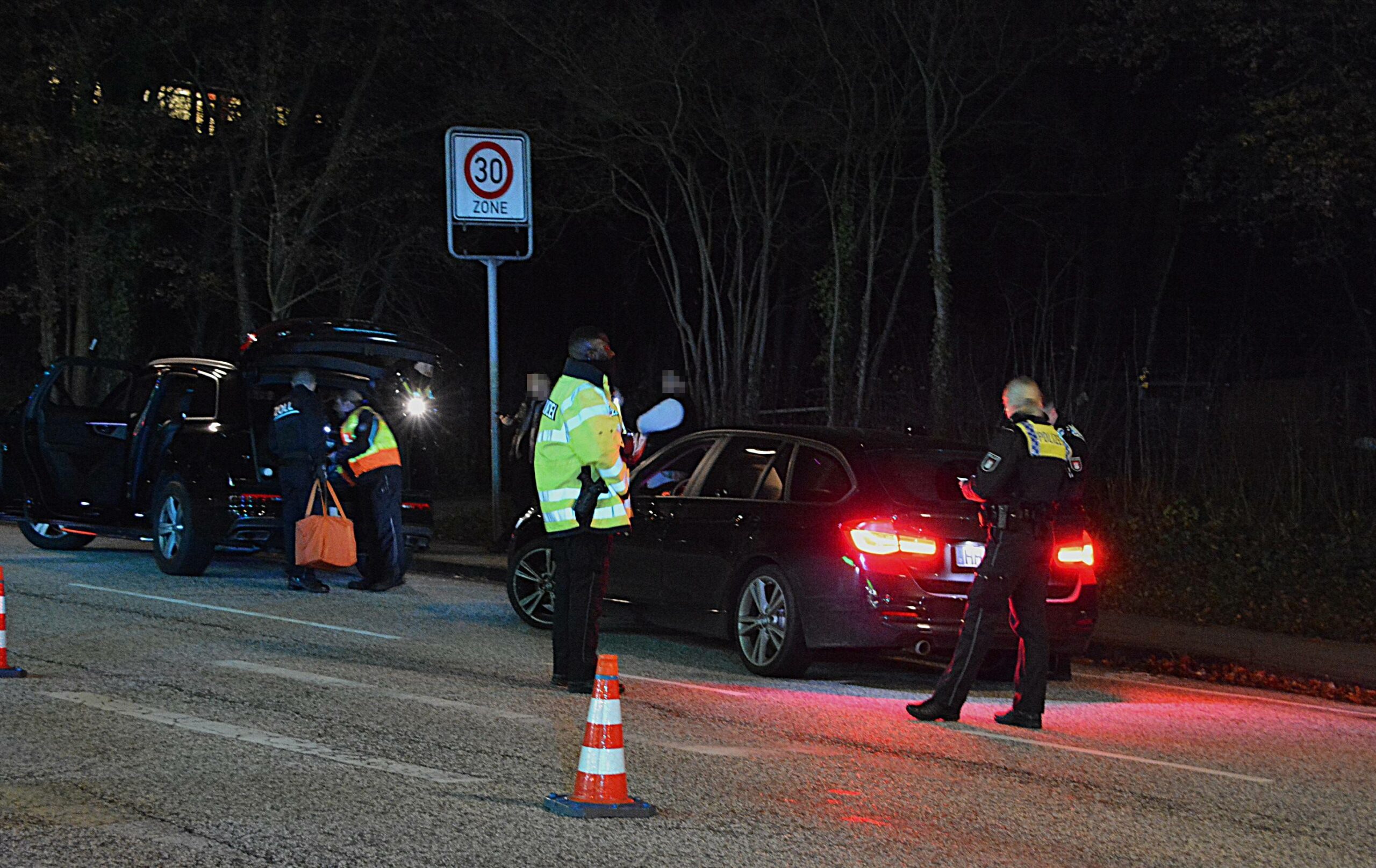 Beamte kontrollieren angehaltene Fahrzeuge.