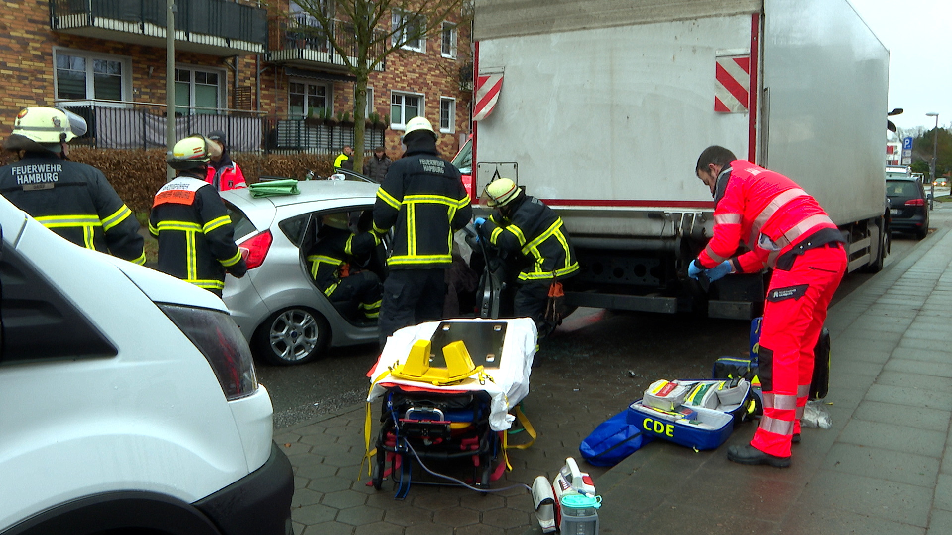 Die Unfallstelle: Feuerwehrleute stehen um ein Auto und einen Lkw herum