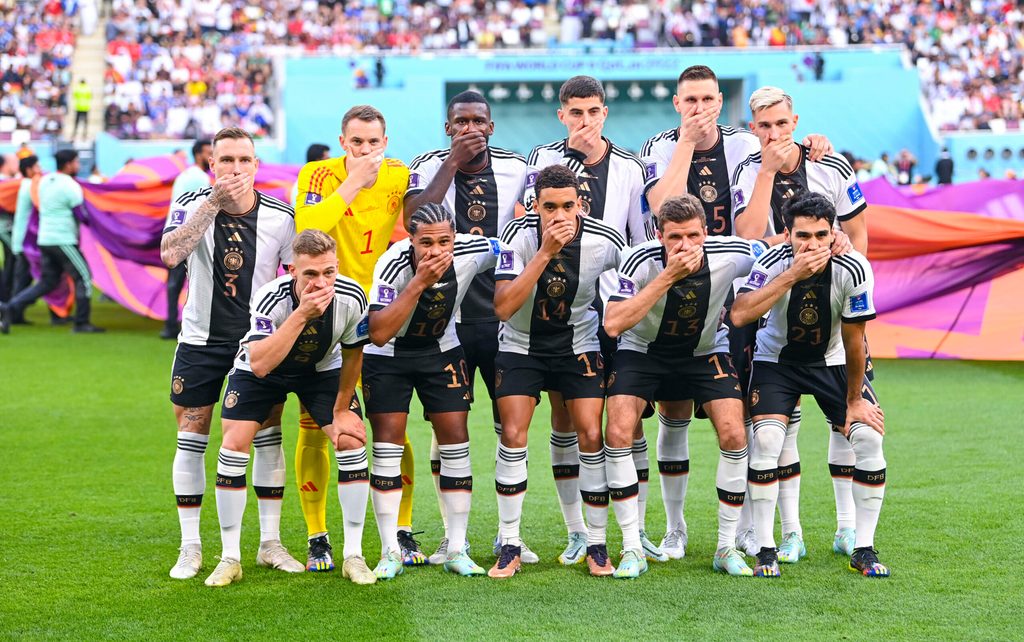 Die deutsche Fußballnationalmannschaft hält sich bei der WM in Katar auf dem Mannschaftsfoto Hände vor den Mund