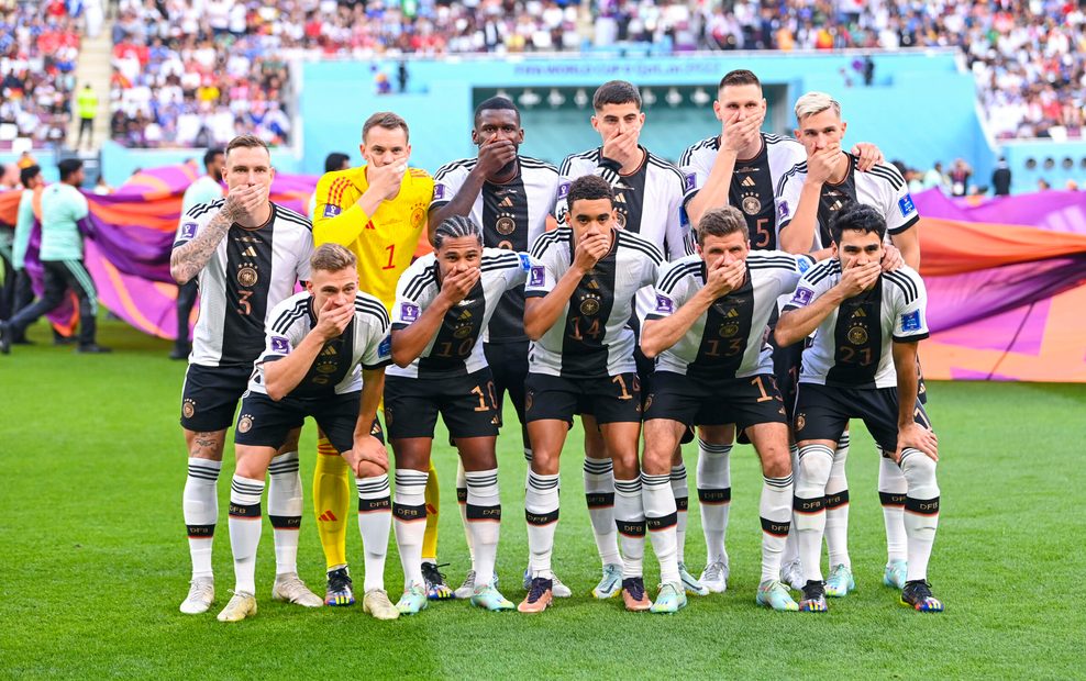 Die deutsche Fußballnationalmannschaft hält sich bei der WM in Katar auf dem Mannschaftsfoto Hände vor den Mund