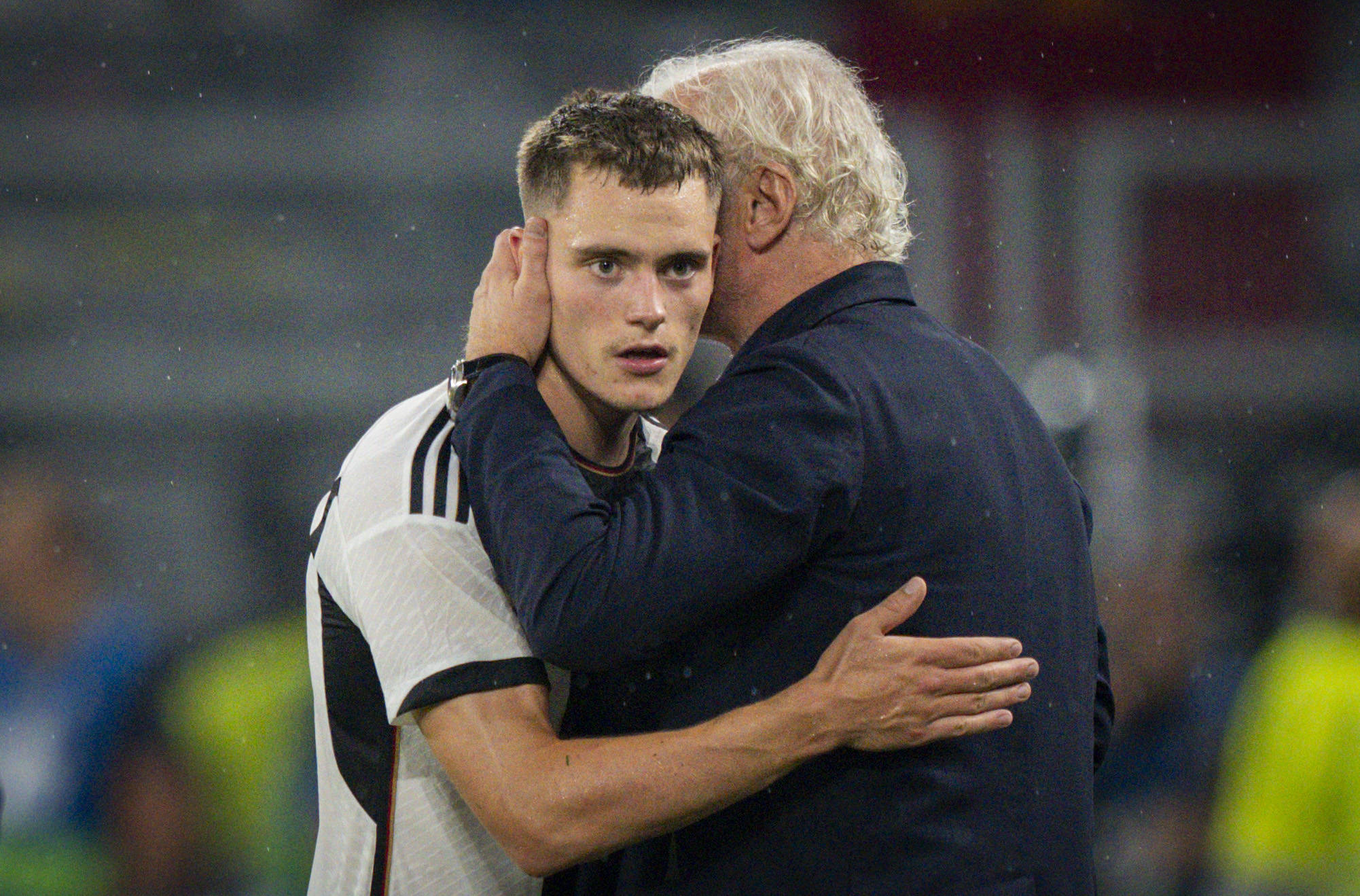 Rudi Völler spricht Florian Wirtz etwas ins Ohr