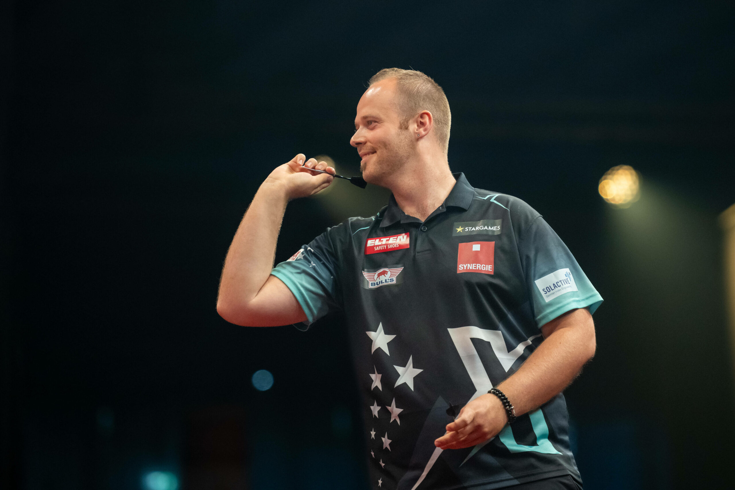 Darts-Profi Max Hopp lächelt beim Wurf