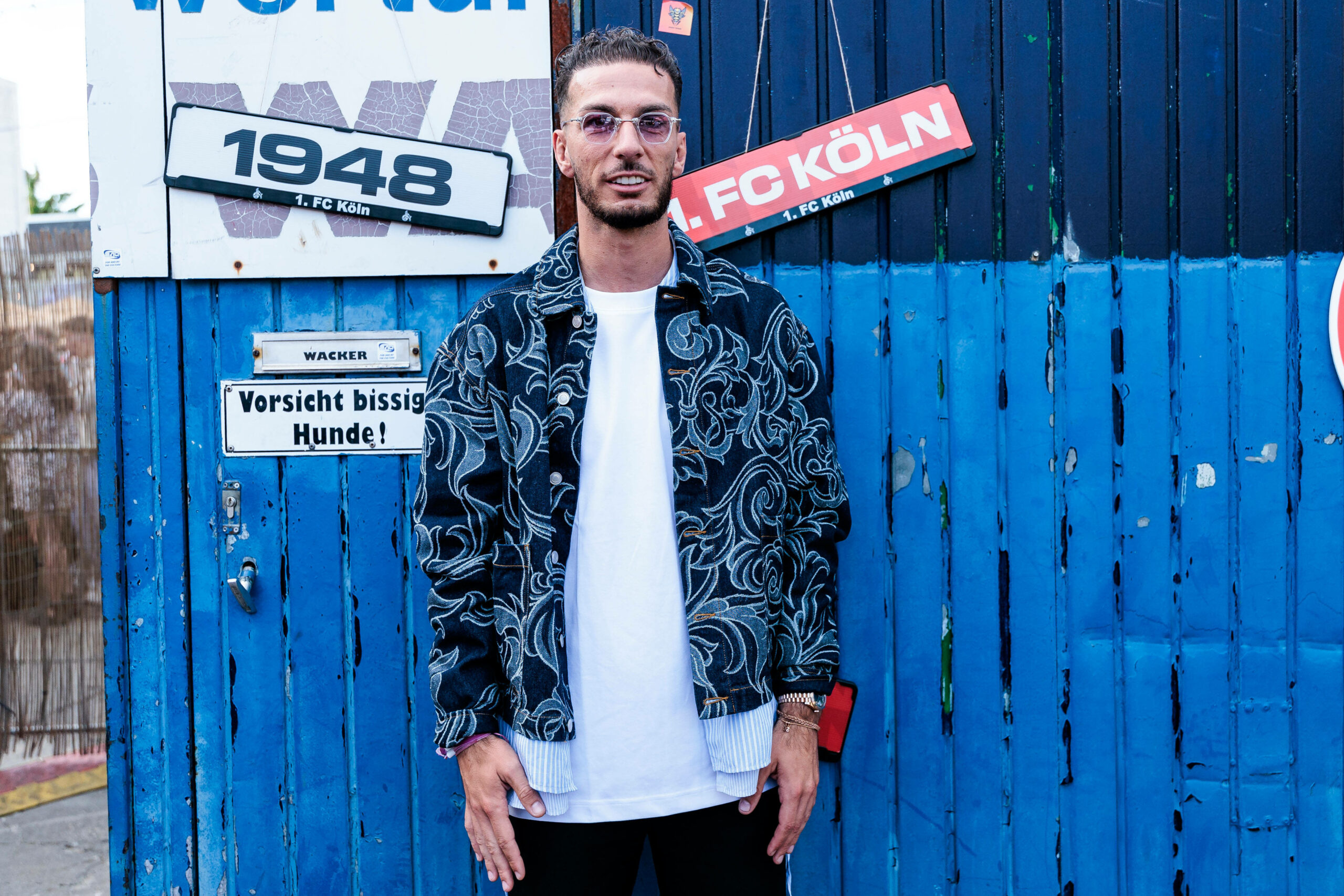 Leart Paqarada vor einem Container des 1. FC Köln