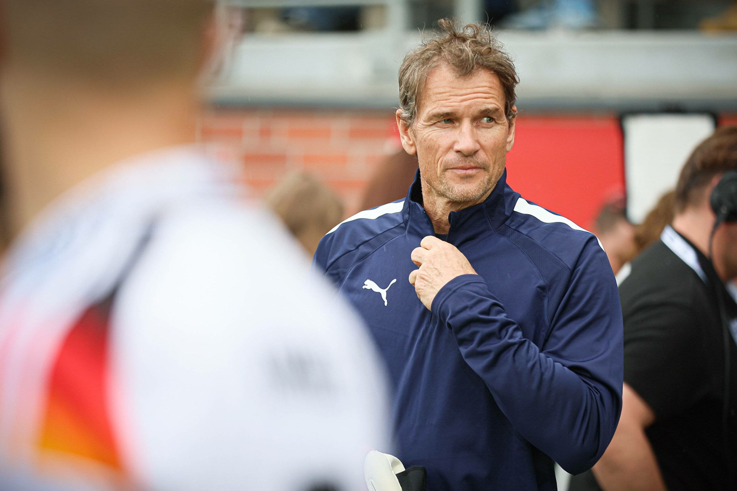 Jens Lehmann zieht sich den Reißverschluss seines Trainingsanzugs hoch.