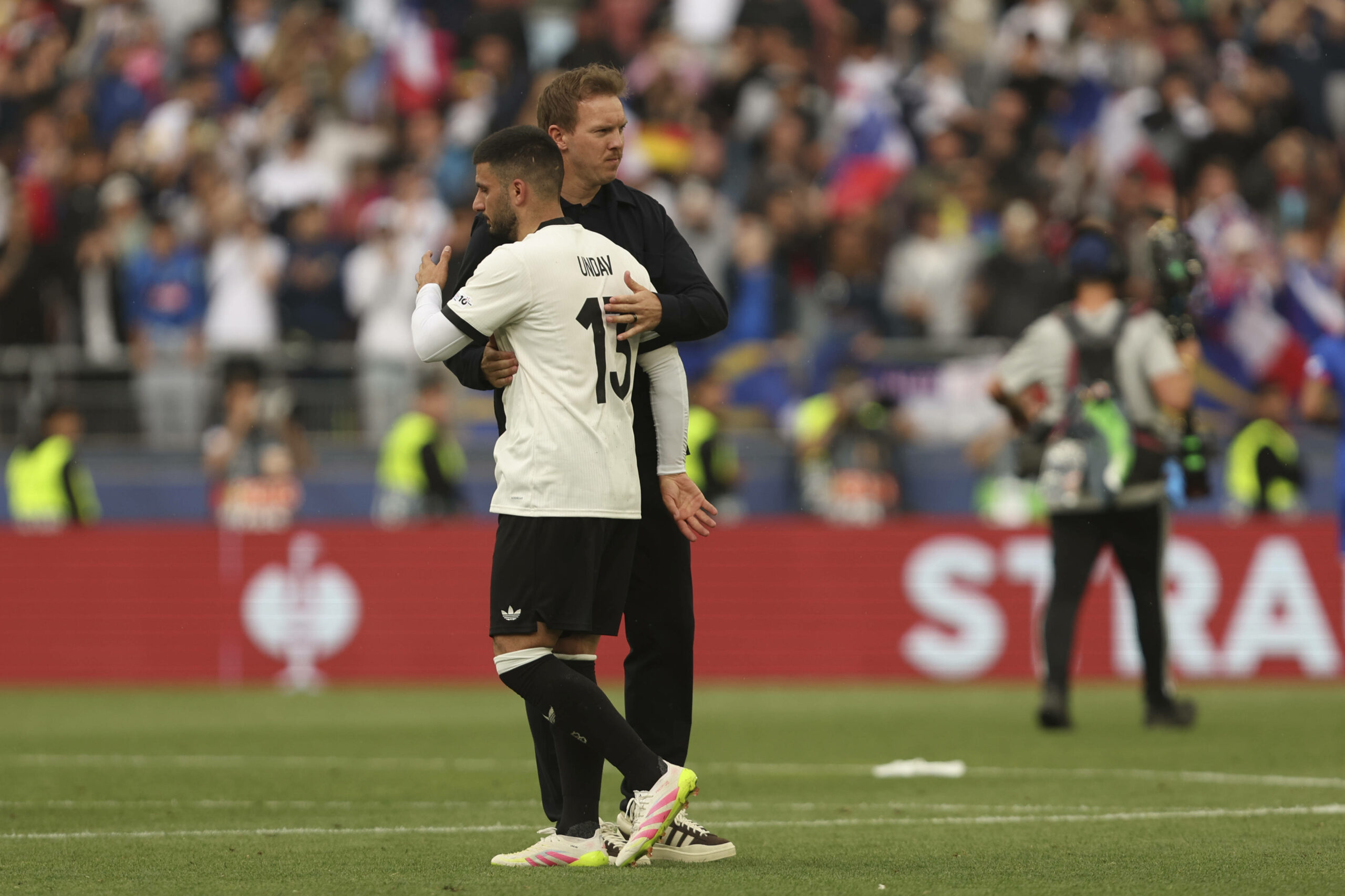 Deniz Undav und Julian Nagelsmann umarmen sich auf dem Spielfeld
