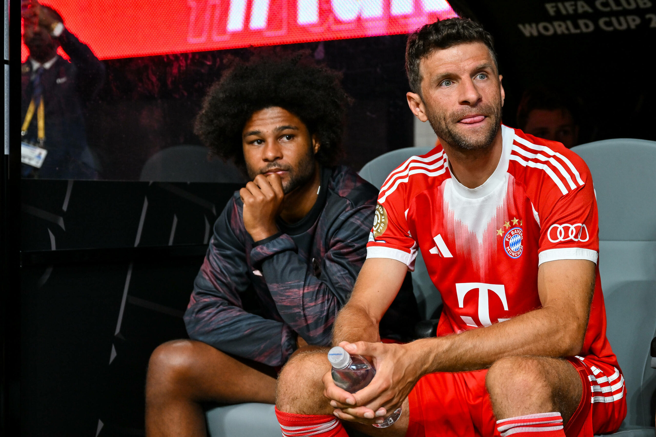 Serge Gnabry und Thomas Müller sitzen auf der Auswechselbank