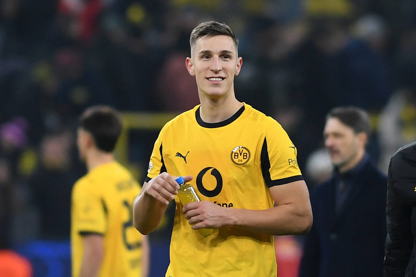 Nico Schlotterbeck hält lächelnd seine Trinkflasche in der Hand