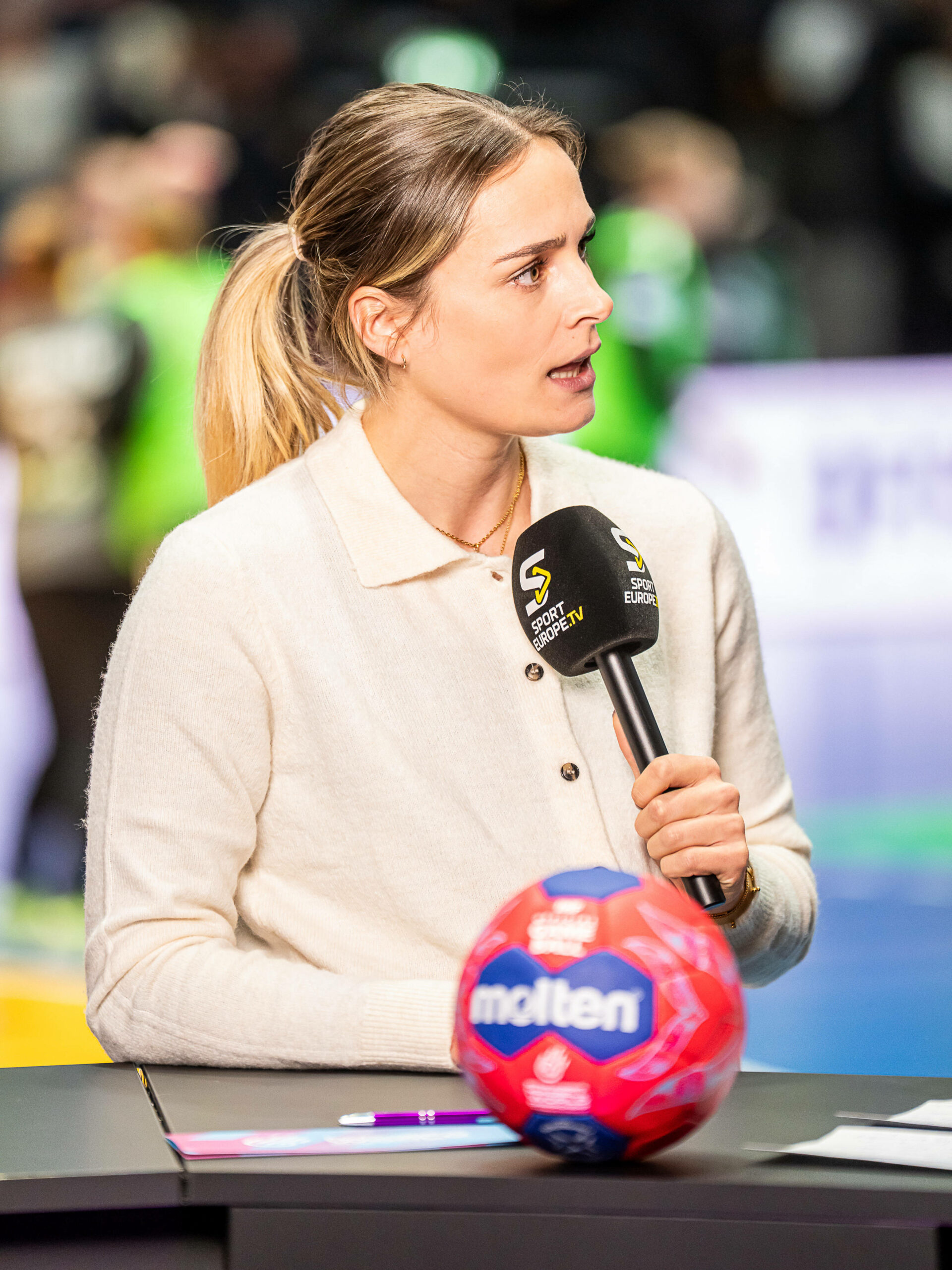 Ex-Handball-Nationalspielerin Dinah Eckerle beim Interview mit Mikrofon in der Hand