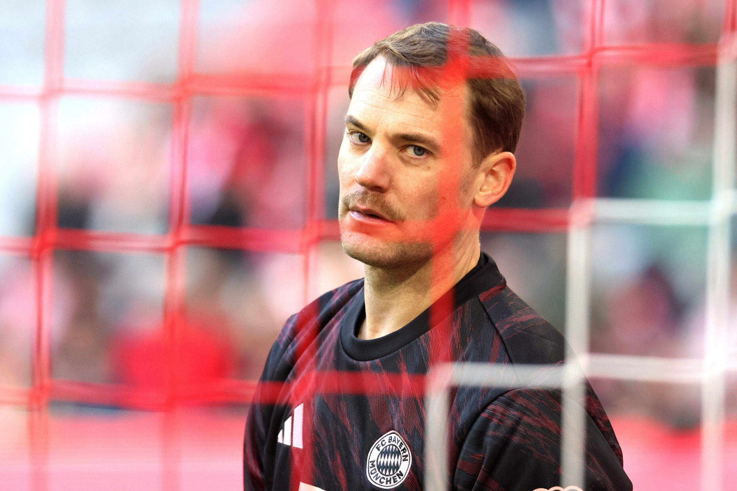 Manuel Neuer schaut genervt durch das Tornetz