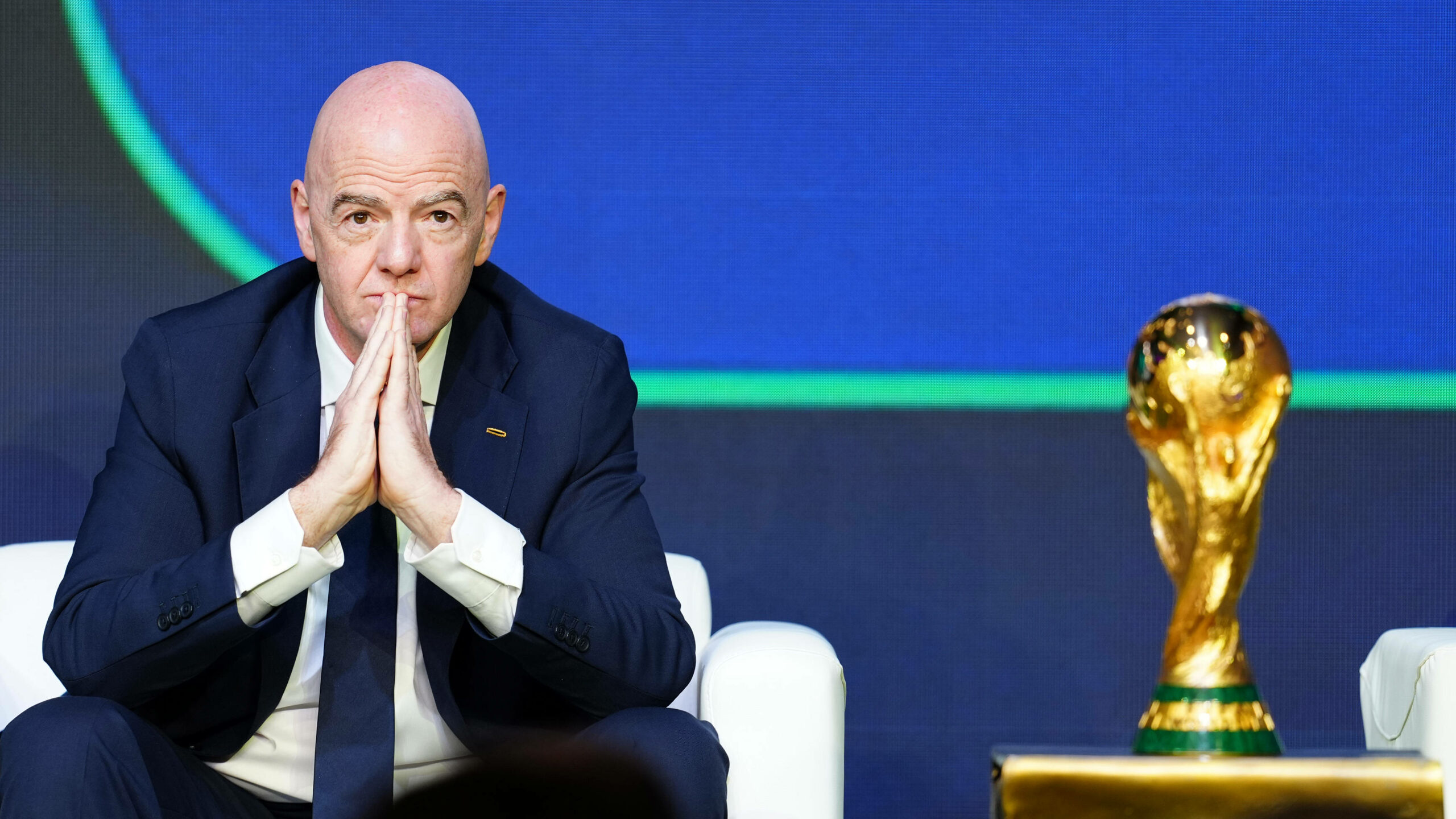 Gianni Infantino faltet die Hände, neben ihm der WM-Pokal.