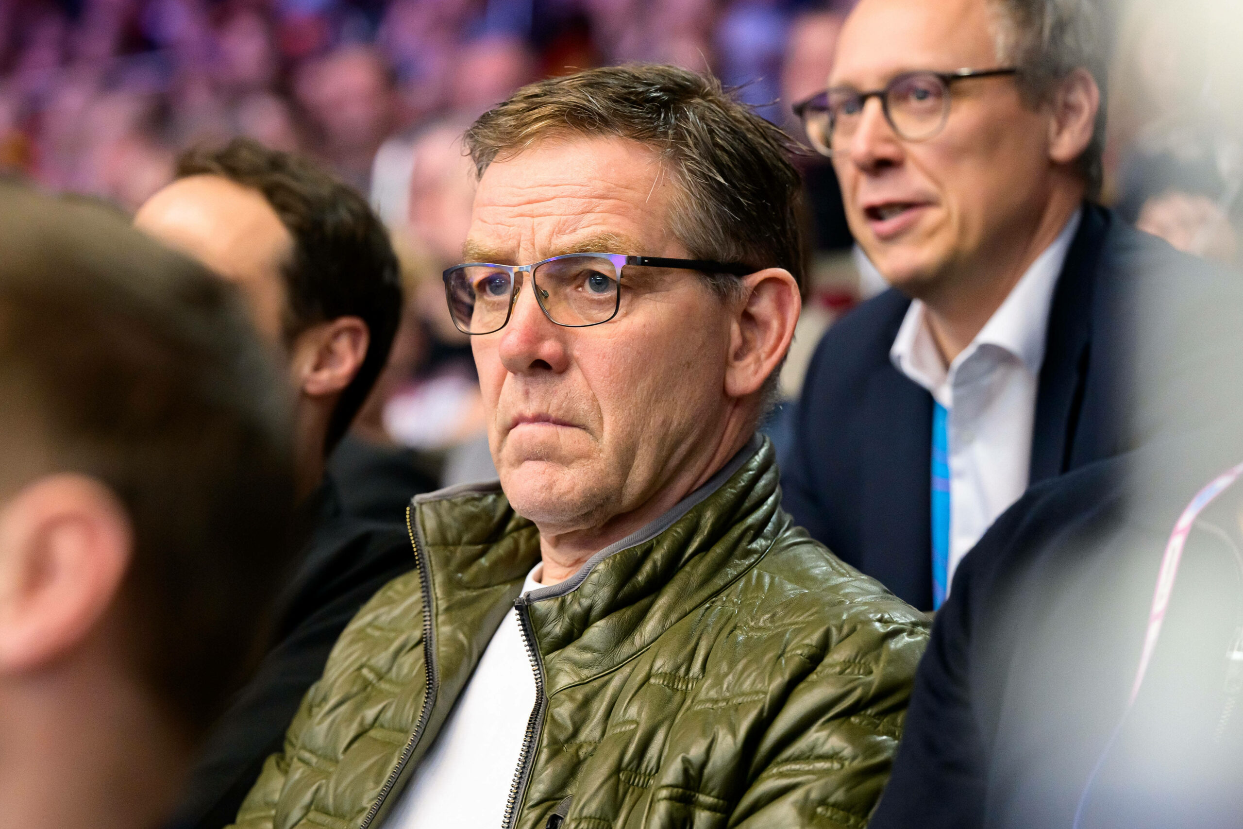 Alfred Gislason als Zuschauer auf der Tribüne mit ernster Miene.