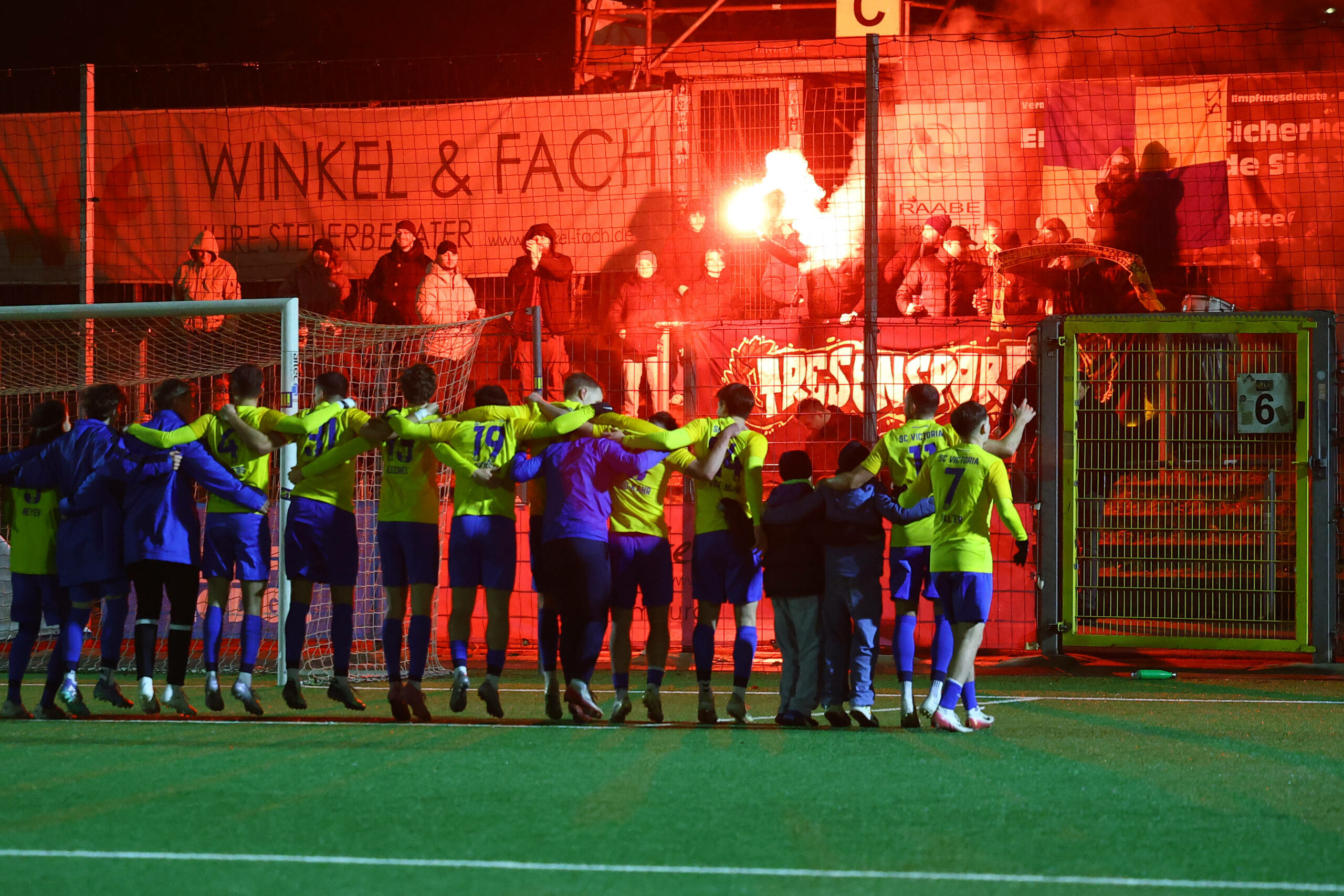 Spieler des SC Victoria feiern vor ihren Fans und einer Pyro-Show den Pokalsieg gegen Altona 93