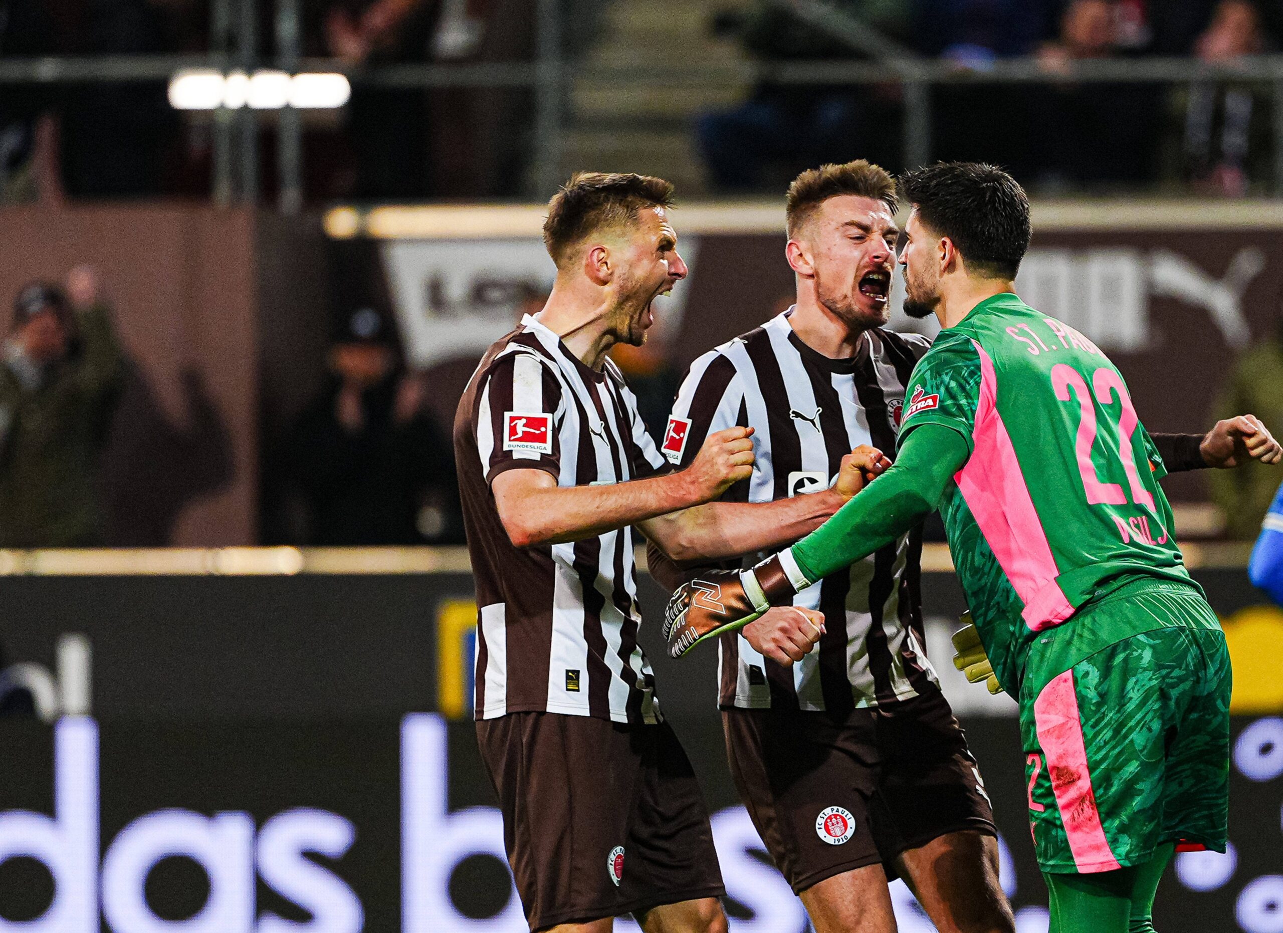 Karol Mets, Hauke Wahl und Nikola Vasilj bejubeln einen Sieg