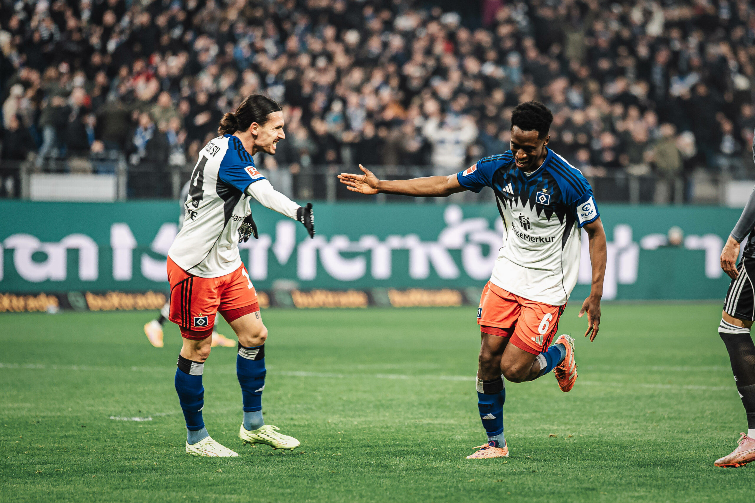 Rayan Philippe und Albert Sambi Lokonga klatschen auf dem Rasen ab.