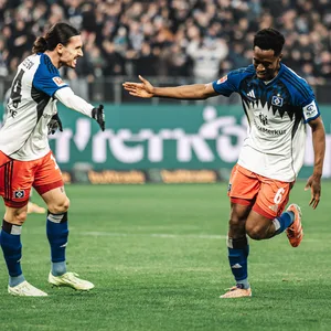 Rayan Philippe und Albert Sambi Lokonga klatschen auf dem Rasen ab.