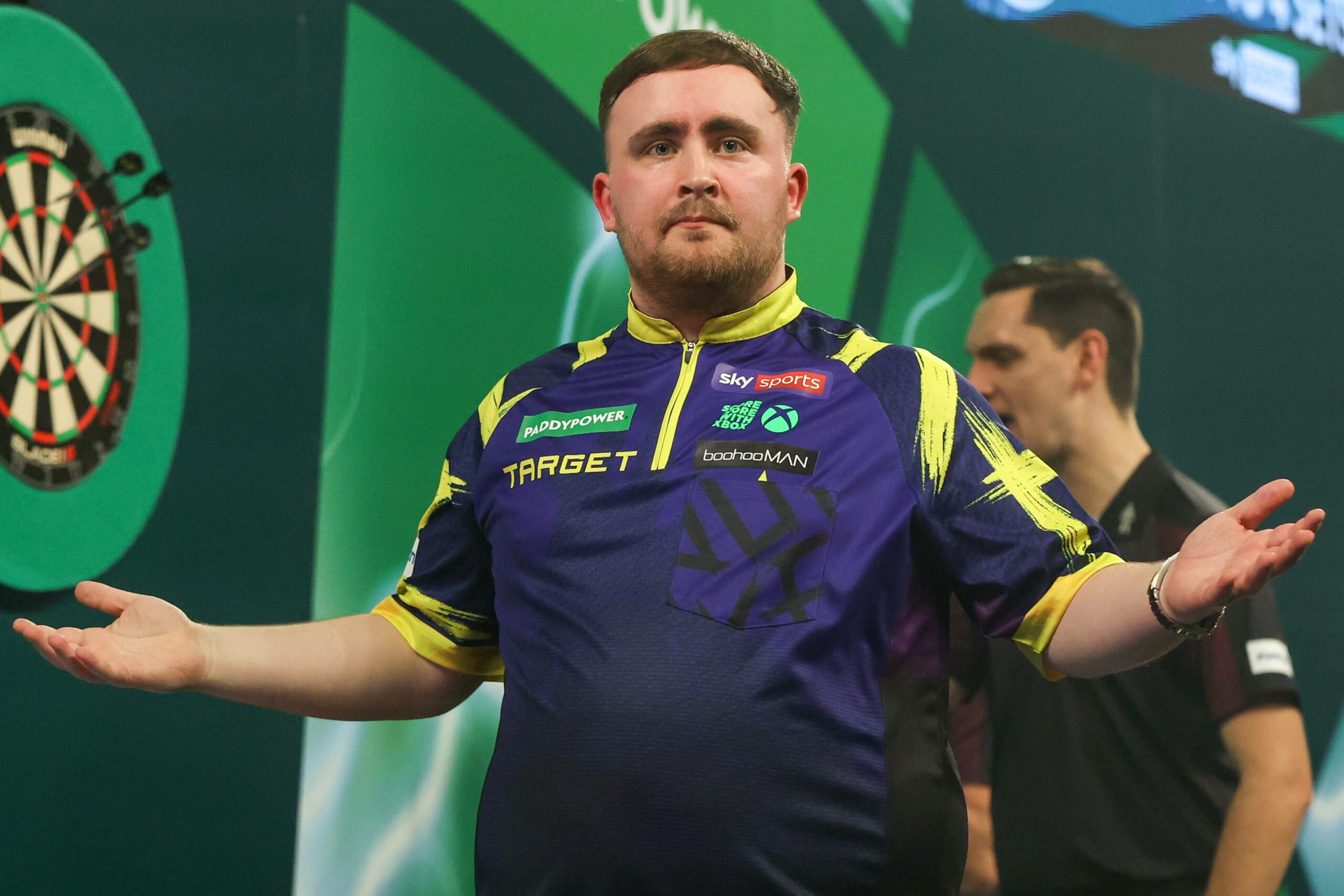 Luke Littler gestikuliert zum Publikum