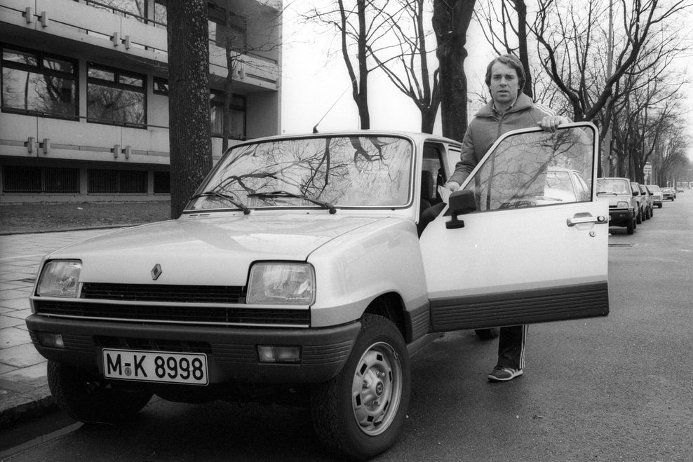 Mann steht an einem weißen Renault, altes Foto