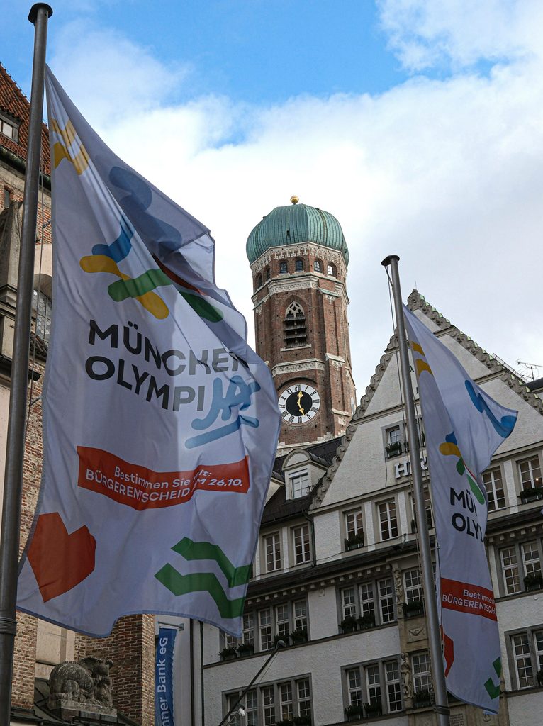 Flagge mit der Aufschrift "OlympiJA" vor der Münchener Frauenkirche