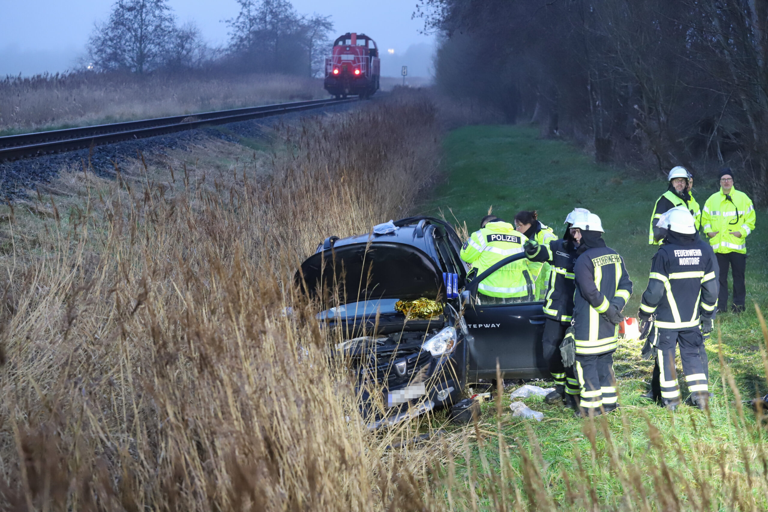 Der völlig zerstörte Wagen der Frau liegt im Graben neben dem Gleis.